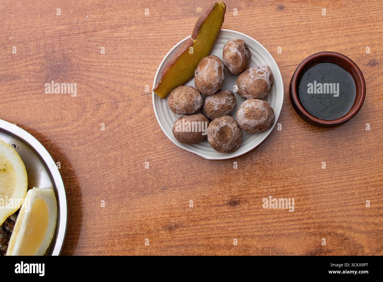 Vista dall'alto delle tradizionali patate rughe delle Canarie servite con patate dolci al forno e salsa verde mojo. Cibo tipico delle Isole Canarie, spagnolo cu Foto Stock