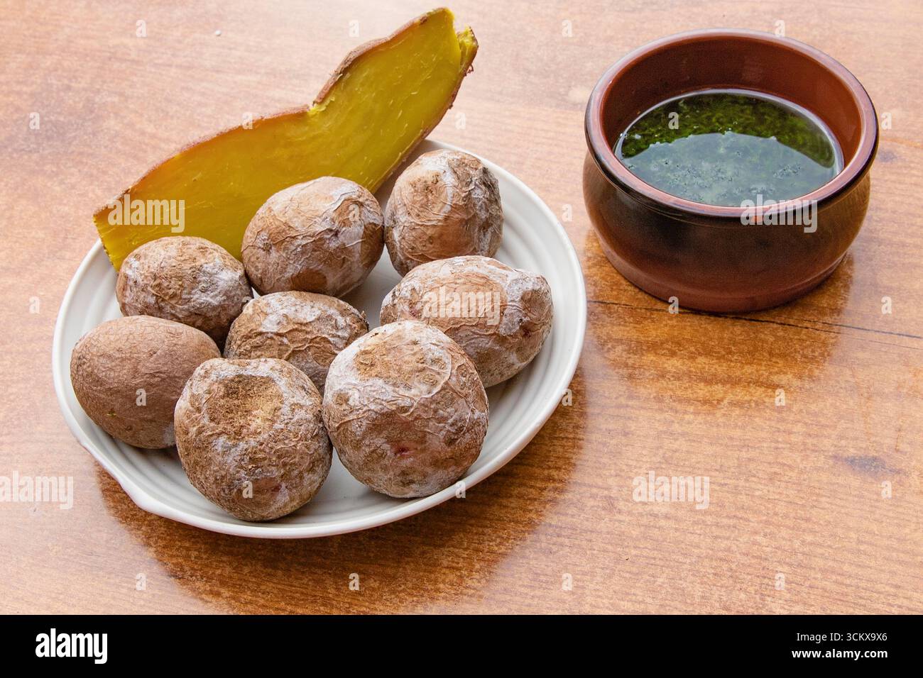 Vista dall'alto delle tradizionali patate rughe delle Canarie servite con patate dolci al forno e salsa verde mojo. Cibo tipico delle Isole Canarie, spagnolo cu Foto Stock