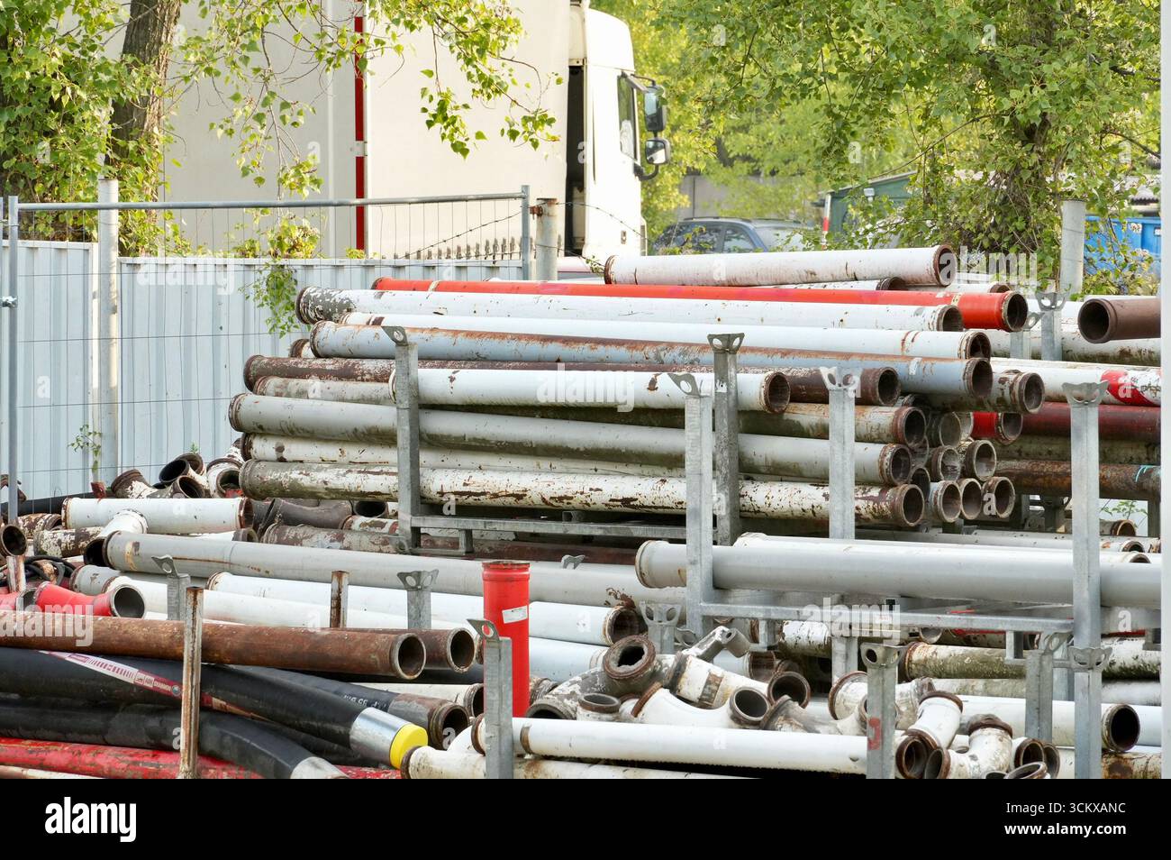 Pile di tubi metallici nel cantiere, primo piano della foto Foto Stock