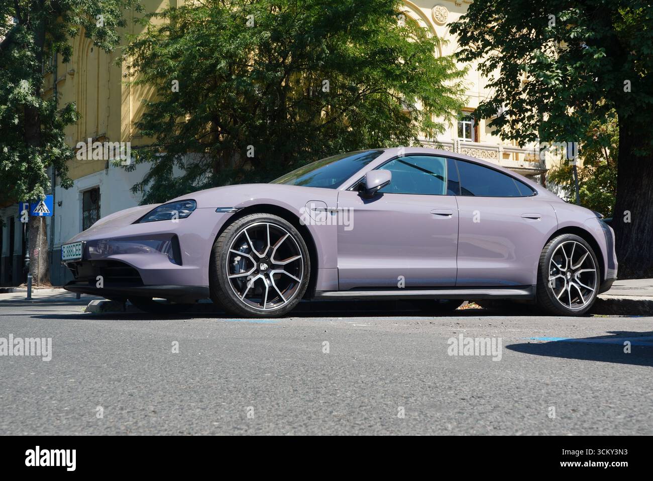 Bucarest, Romania – 10 agosto 2025: Vista ravvicinata dell'auto di lusso Porsche Taycan parcheggiata nel centro della città Foto Stock