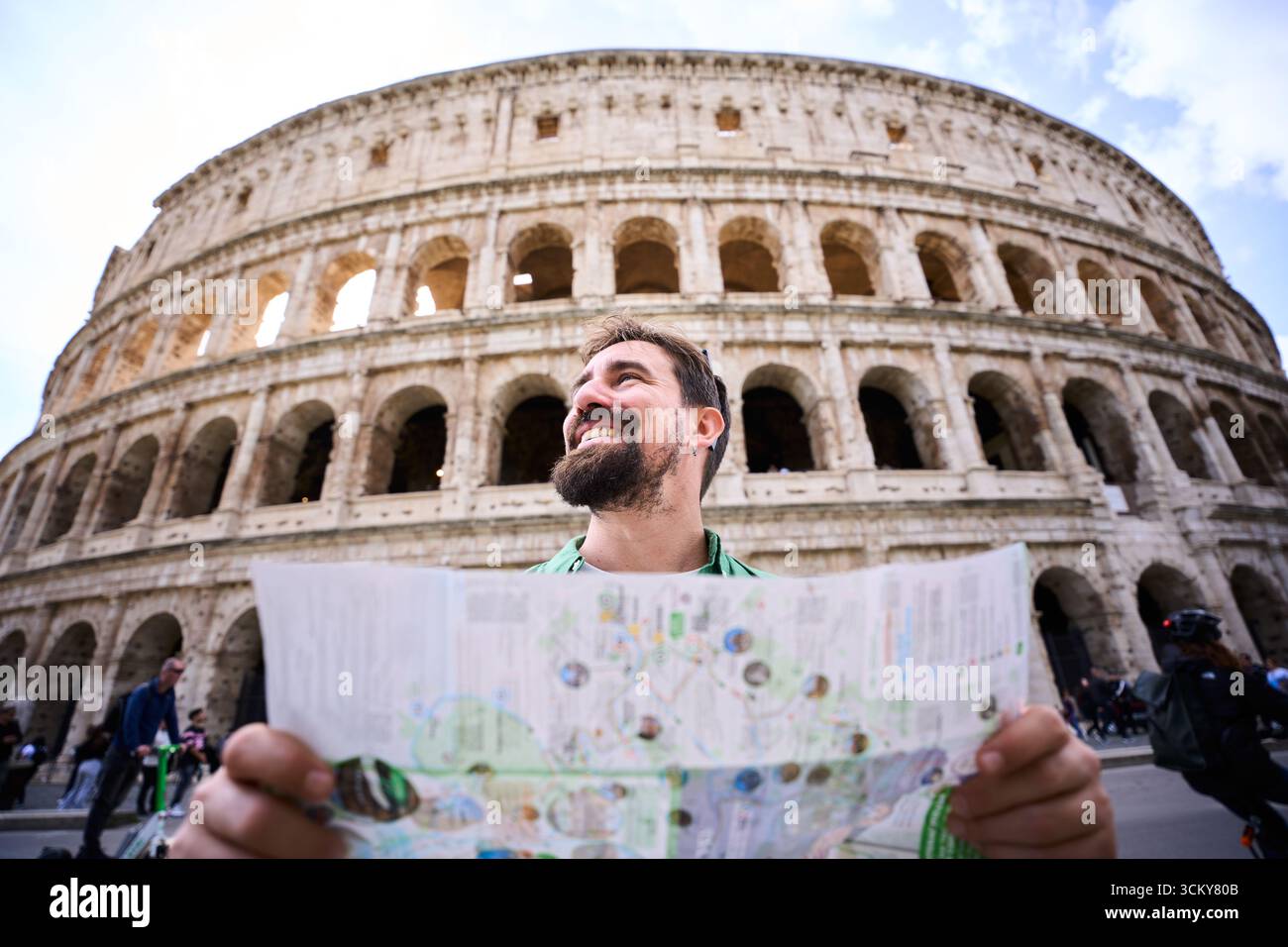 Uomo caucasico che tiene una mappa fuori dal Colosseo di Roma Foto Stock