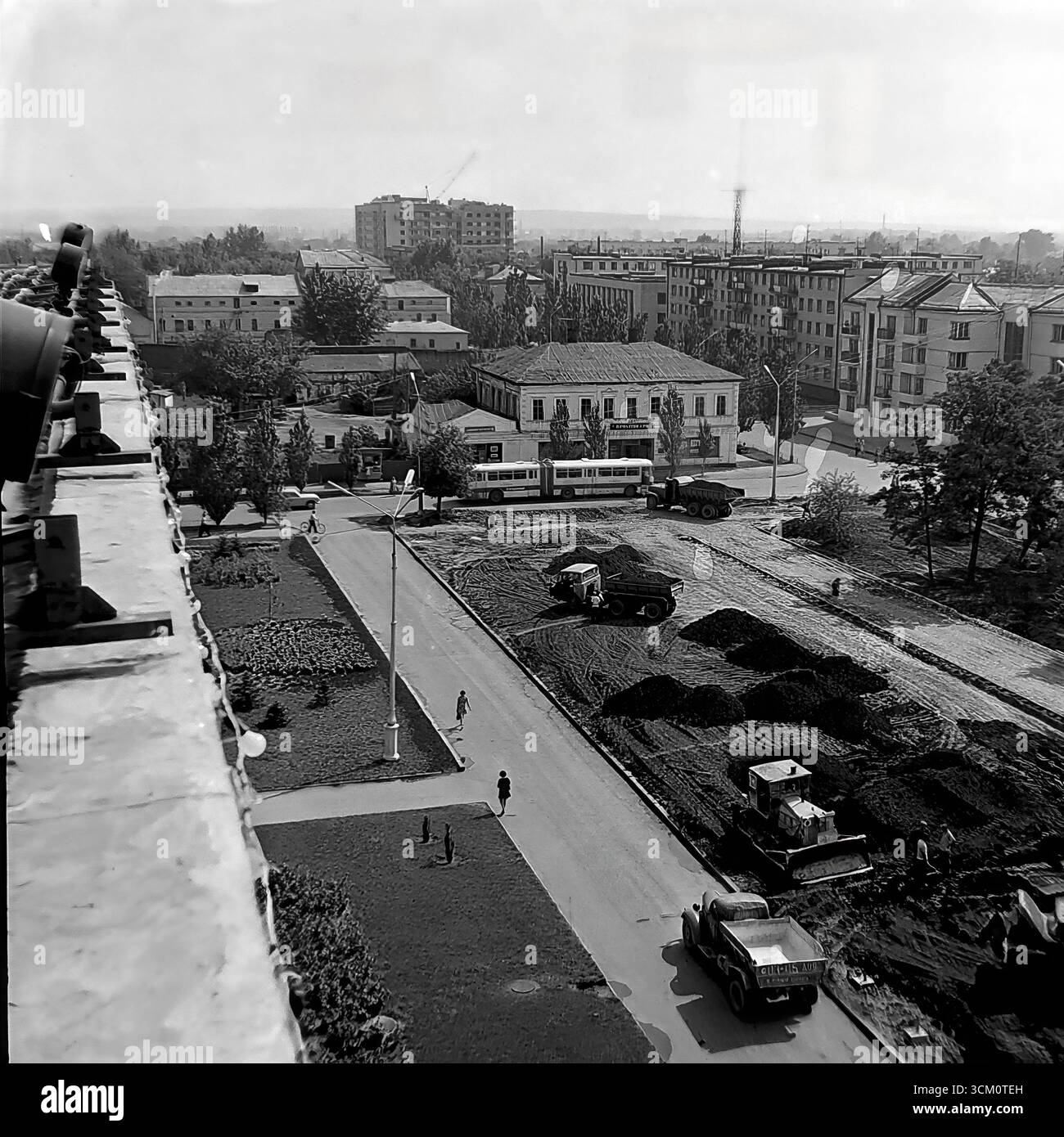 Una ricostruzione su larga scala della piazza centrale della Rivoluzione d'ottobre a Sloviansk, 1975-1976, alla vigilia del 300° anniversario della città. La foto cattura macchinari pesanti come bulldozer e dumper al lavoro, insieme al trasporto urbano funzionante come un filobus, durante il massiccio progetto di rinnovamento urbano. Questa fotografia è un potente documento di pianificazione urbana sovietica e un simbolo della vita creativa e pacifica nel Donbas, dove la città veniva attivamente trasformata per la sua grande celebrazione del giubileo Foto Stock