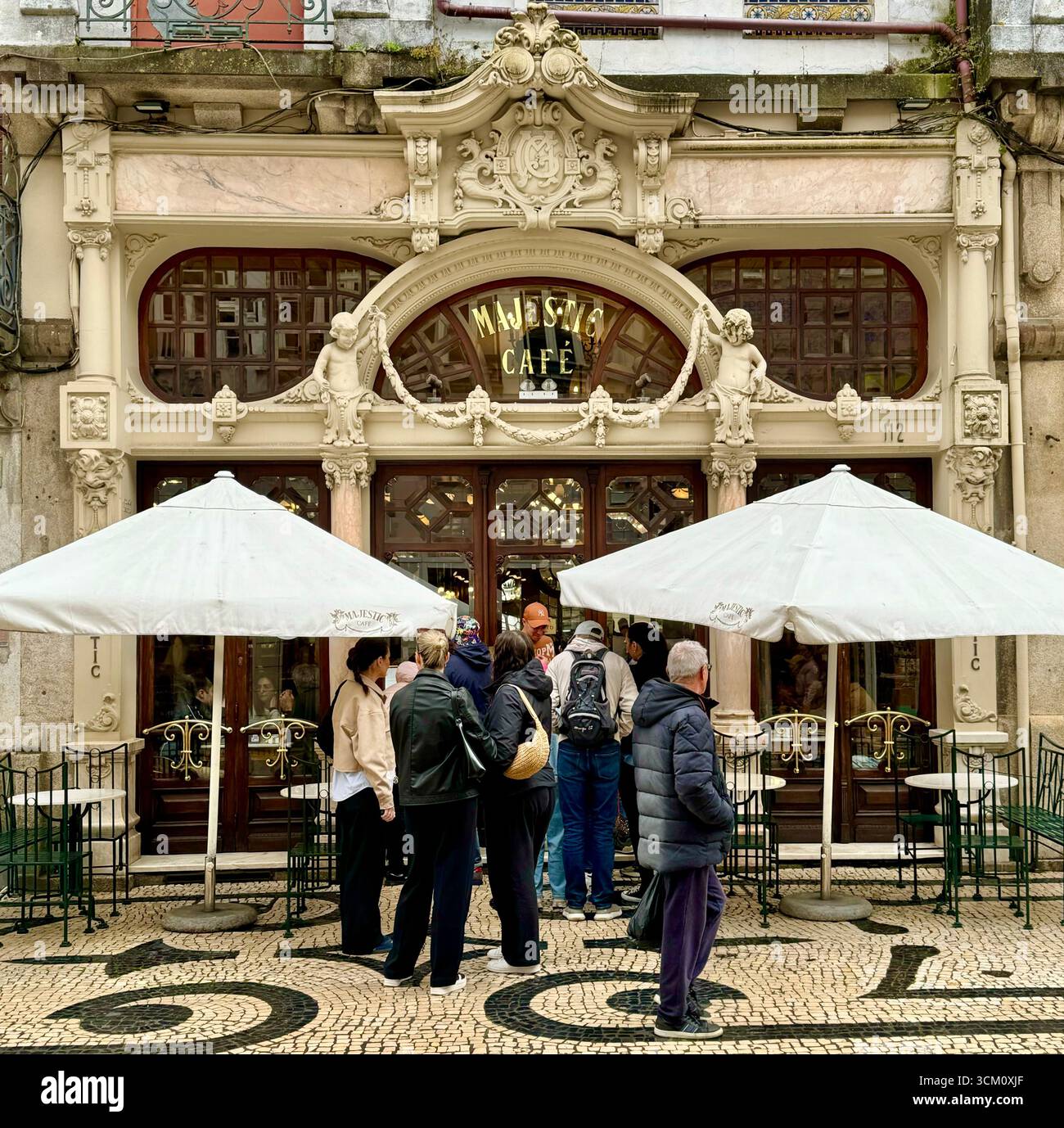 Fila di persone fuori dal caffè Art Nouveau Majestic Cafe su Rua de Santa Catarina nel centro storico di Porto, Portogallo - Immagine stock catturata con smartphone