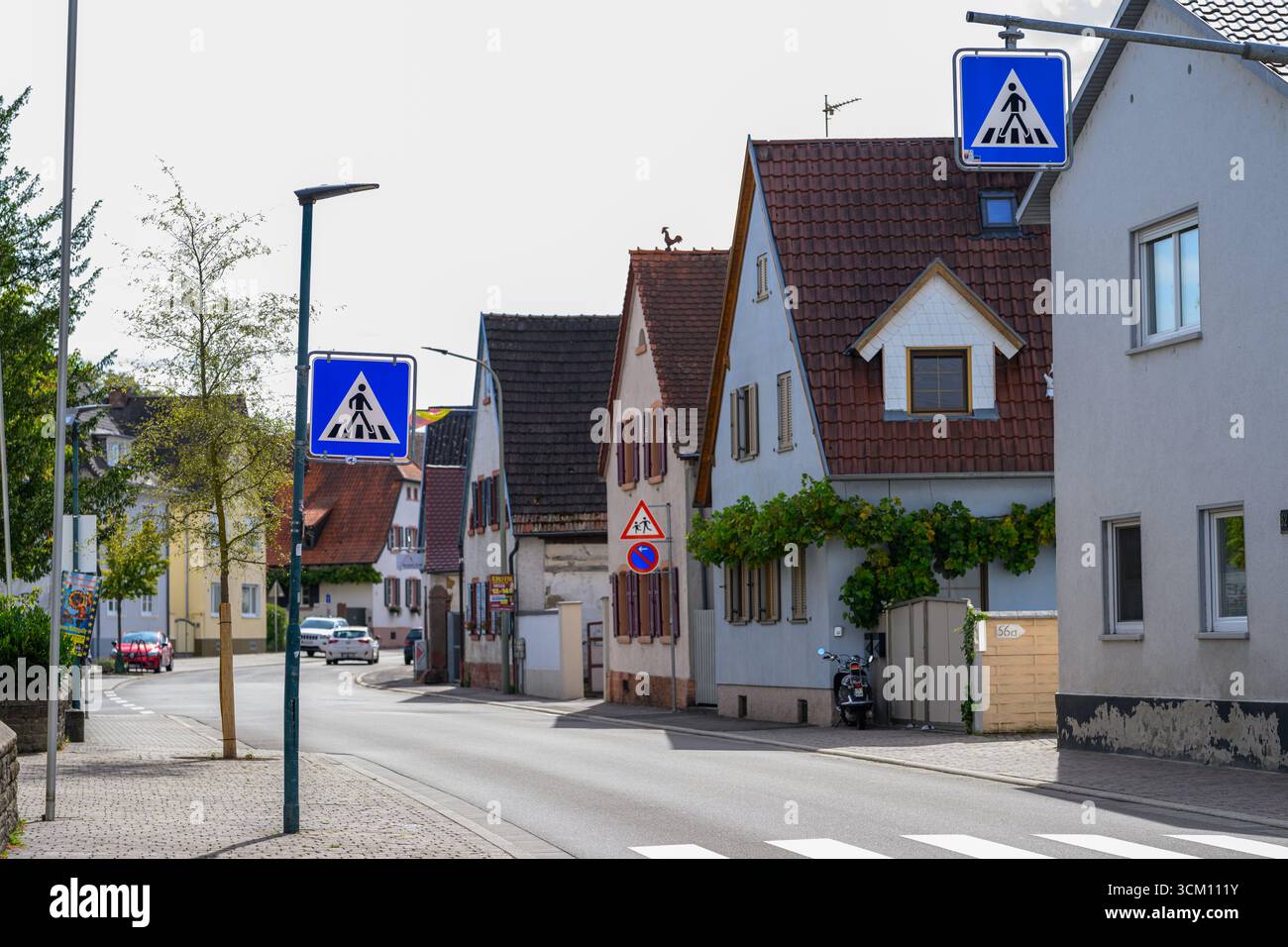 , Deutschland, Rheinland-Pfalz, Berghausen, 13.09.2025, Wohnstraße mit Zebrastreifen und mehreren Verkehrsschildern für Fußgängerüberwege. Link und Foto Stock
