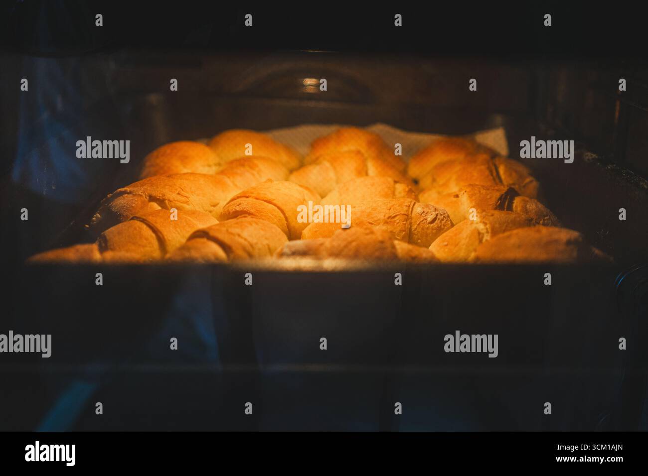 Panini fatti in casa cotti nel forno, una scena della vita quotidiana a casa. Foto Stock