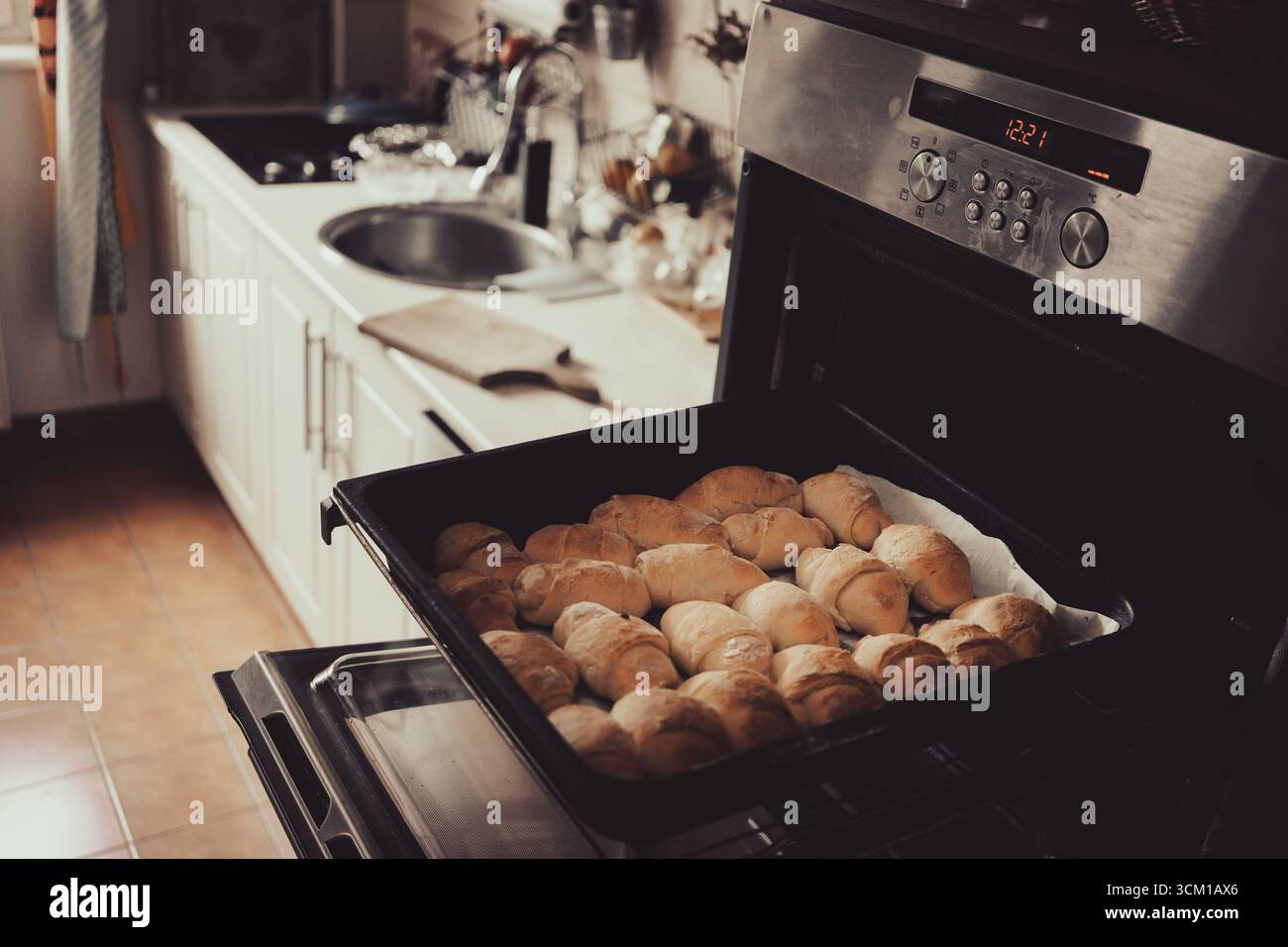 Panini fatti in casa cotti nel forno, una scena della vita quotidiana a casa. Foto Stock