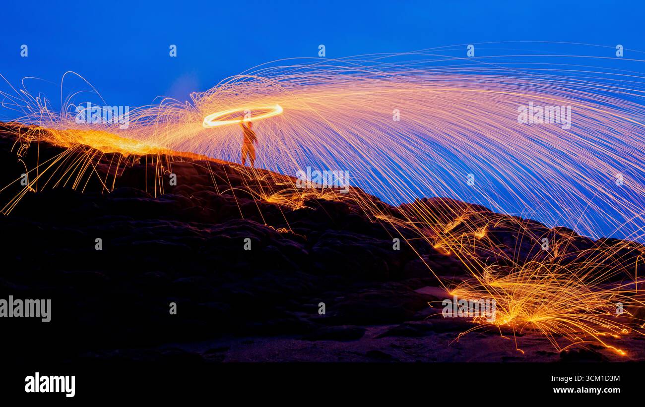 Fotografia di lana d'acciaio sotto un cielo blu subito dopo il tramonto sulla spiaggia, creando un'illuminazione spettacolare. Foto Stock