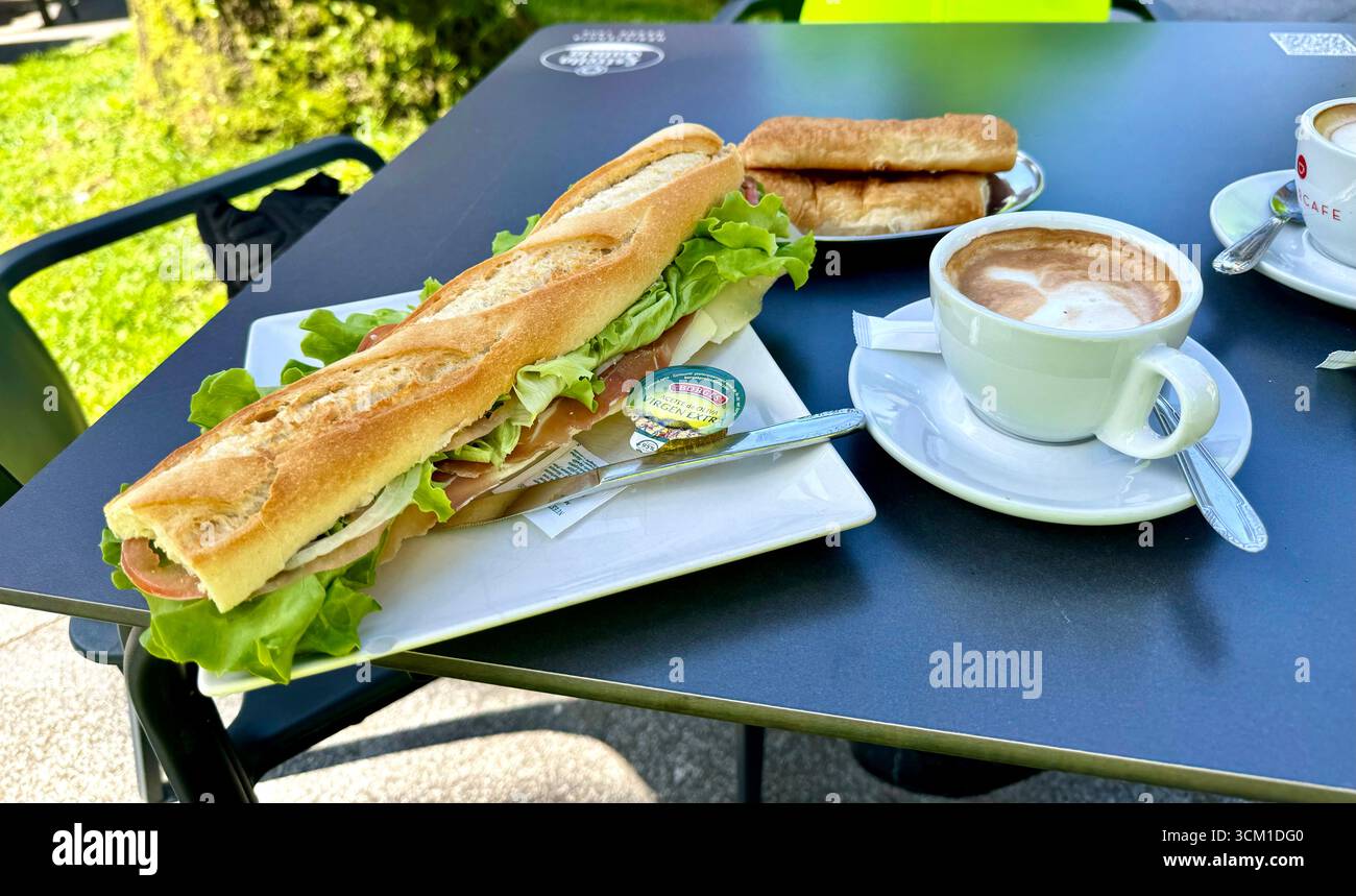 Pranzo a base di baguette prosciutto crudo e insalata e una tazza di caffè cappuccino - Immagine stock catturata con smartphone