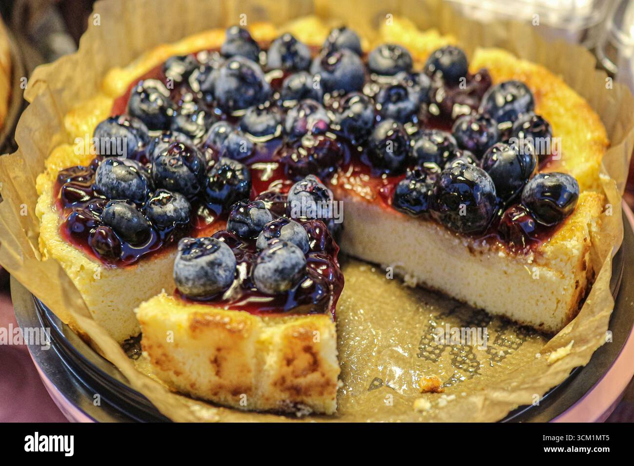 Torta ai mirtilli con frutti di bosco freschi e marmellata lucida, crosta dorata con consistenza umida, perfetta per la panificazione e lo styling degli alimenti. Foto Stock