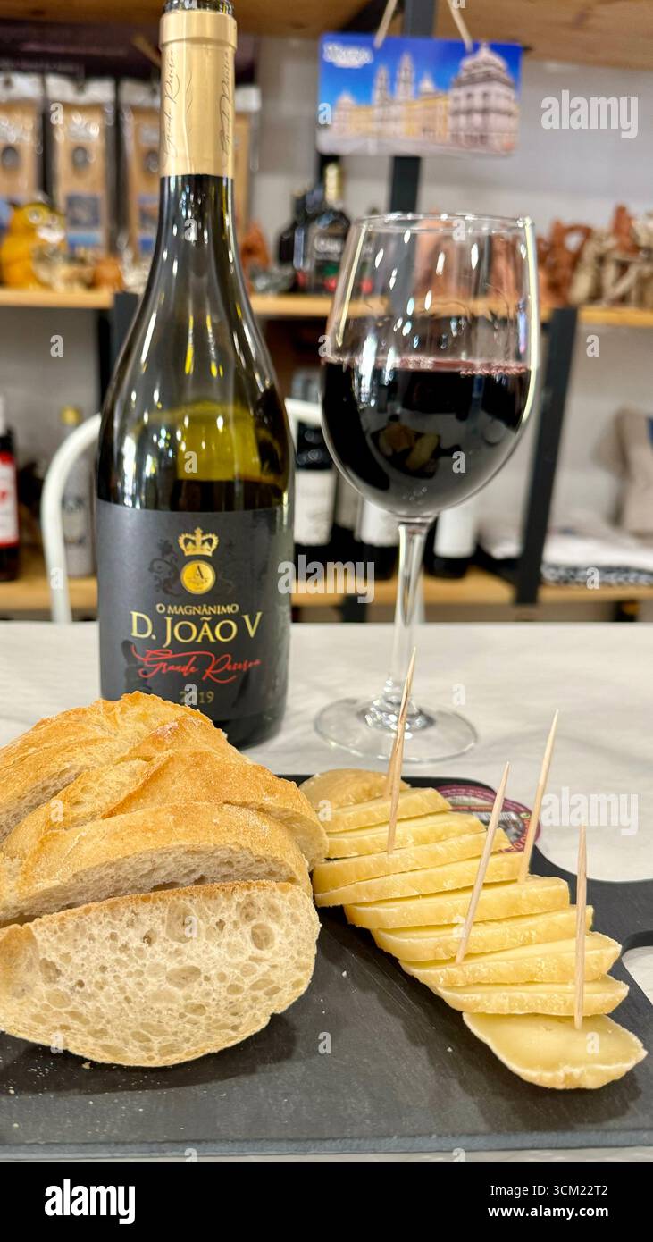 Bottiglia di vino rosso portoghese e un semplice tagliere di formaggi Foto Stock