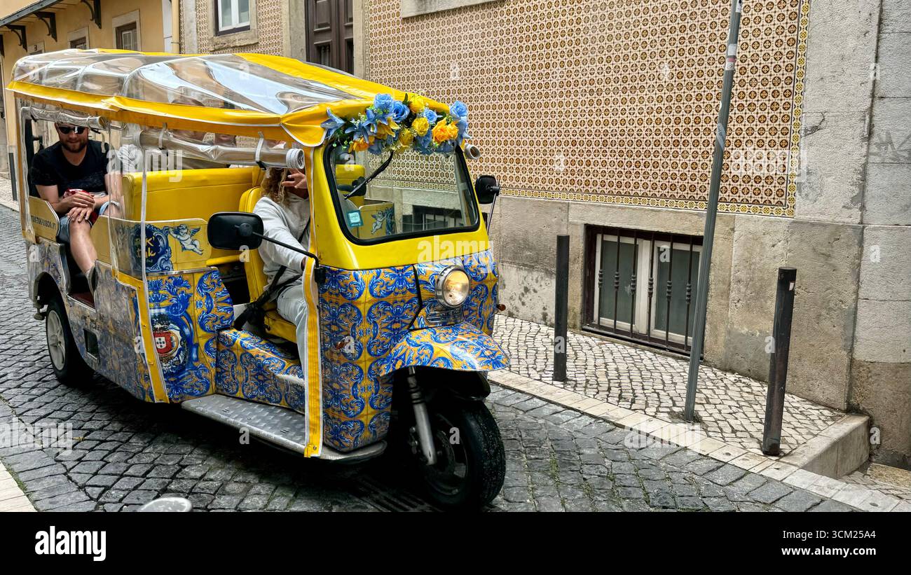 Buggy a ruote con tuk tuk utilizzato per trasportare i turisti attraverso le strette strade di Alfama Lisbona Portogallo - Immagine stock catturata con smartphone
