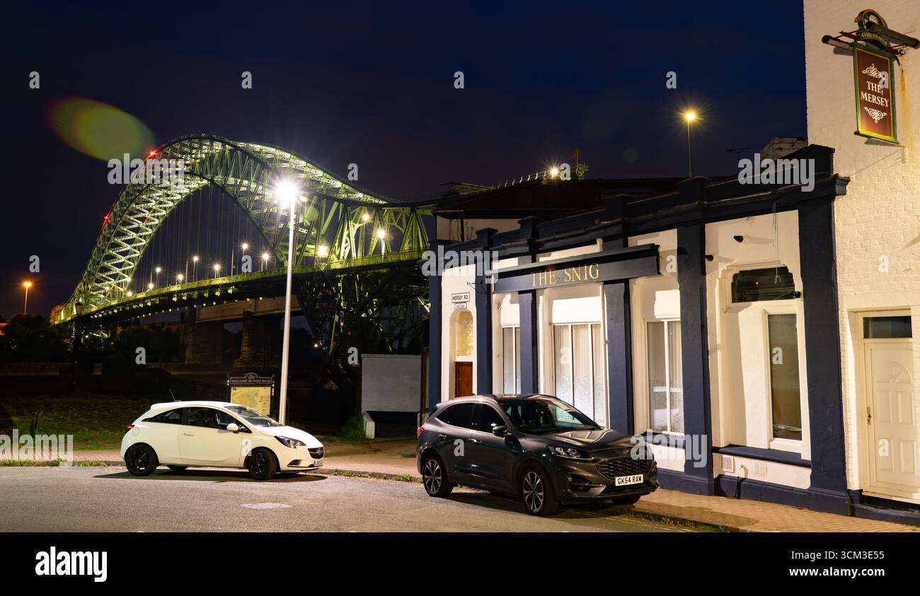 Il Mersey Pub, con il Silver Jubilee Bridge adiacente a Widnes lungo la sponda occidentale del fiume Mersey. Immagine scattata nell'agosto 2025. Foto Stock