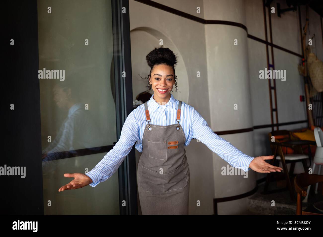 Caffè sicuro, proprietario di un ristorante in piedi con le braccia incrociate, che dà il benvenuto ai clienti al bar Foto Stock