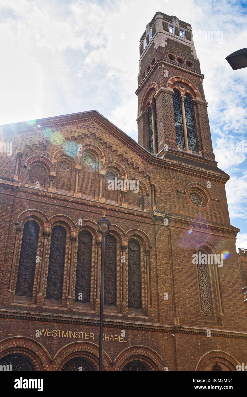 Un edificio soleggiato in mattoni con un'alta torre, caratterizzato da finestre ad arco e dettagli decorati. La "Westminster Chapel" è incisa qui sotto a Londra, U Foto Stock