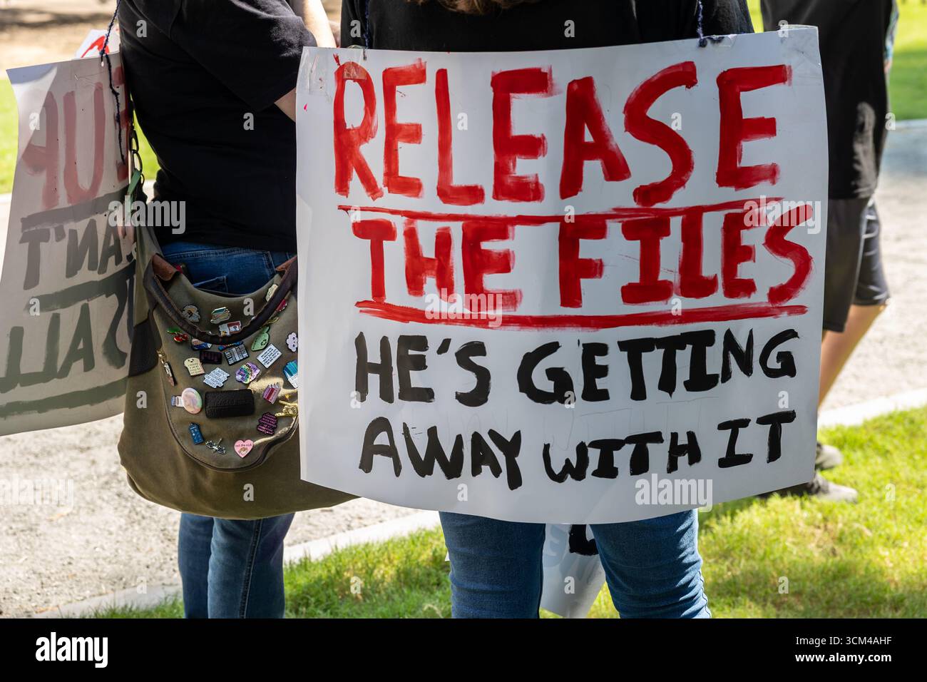Atlanta, GA / USA - 1 settembre 2025: Donna indossa un cartello con la scritta "Release the files, He's Getting With IT" al rally Workers Over Billionaires. Foto Stock