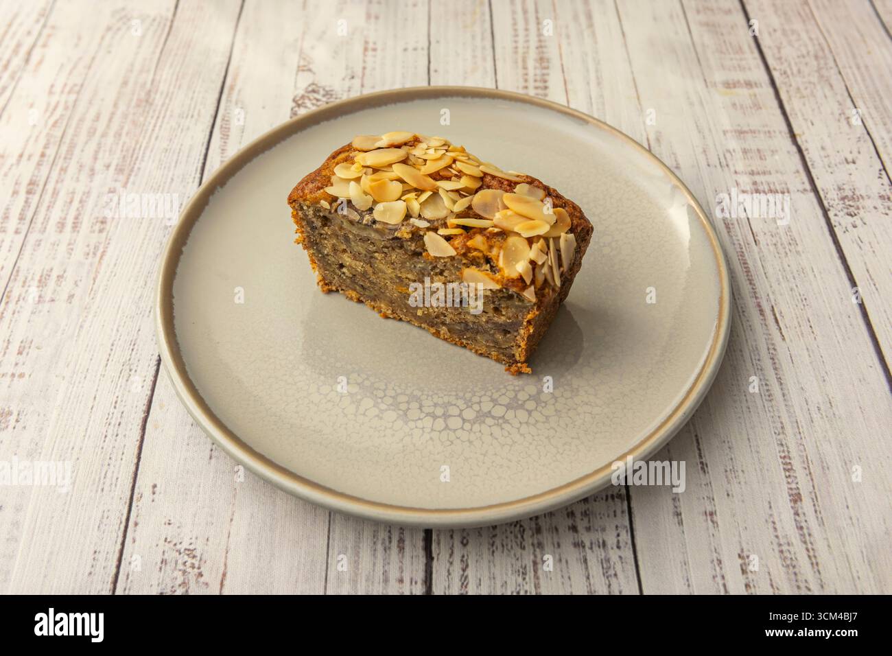 Pan di Spagna alla carota con pezzi di noci e uvetta, cosparso di cannella e ricoperto da una crema di formaggio liscio e decorazioni rustiche Foto Stock