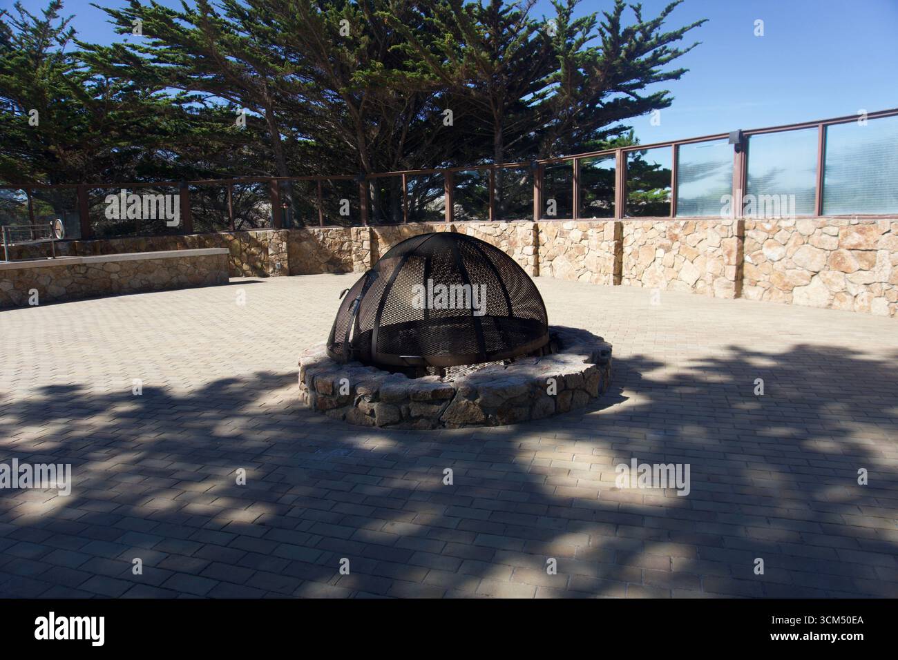 Caminetto in pietra all'aperto con copertura a cupola in metallo sul patio Foto Stock