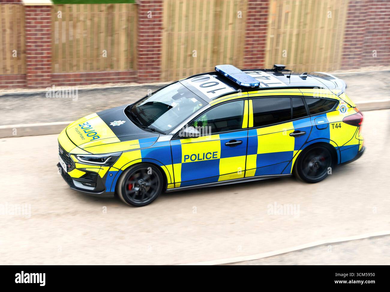 Una moderna pattuglia della polizia britannica della northumbria che guida su una strada, mostrando una livrea a scacchi blu e gialla distinta dal Regno Unito Foto Stock