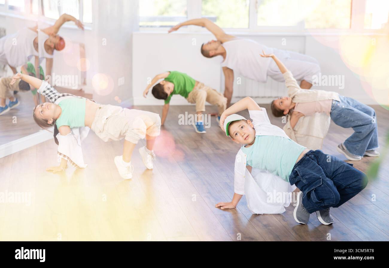 Ragazzo preadolescente che fa danza hip hop durante la lezione di gruppo Foto Stock