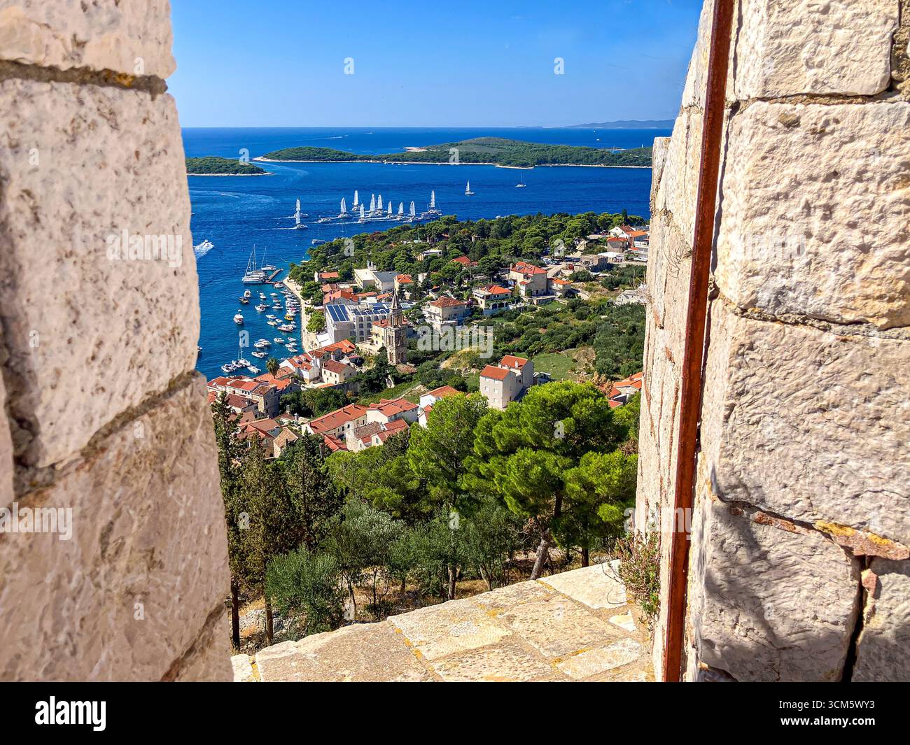 Vista in alto sopra la città di Hvar dalla fortezza in alto. Una gemma croata e antica città con strade acciottolate, architettura veneziana e acque cristalline. Foto Stock