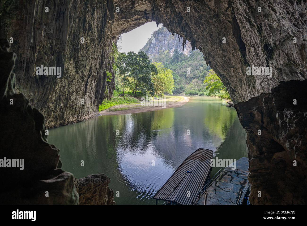 Vista dall'interno di una grotta calcarea che si affaccia su un fiume e sulle montagne lussureggianti del lago Ba Bể a Bắc Kạn, Vietnam. Foto Stock