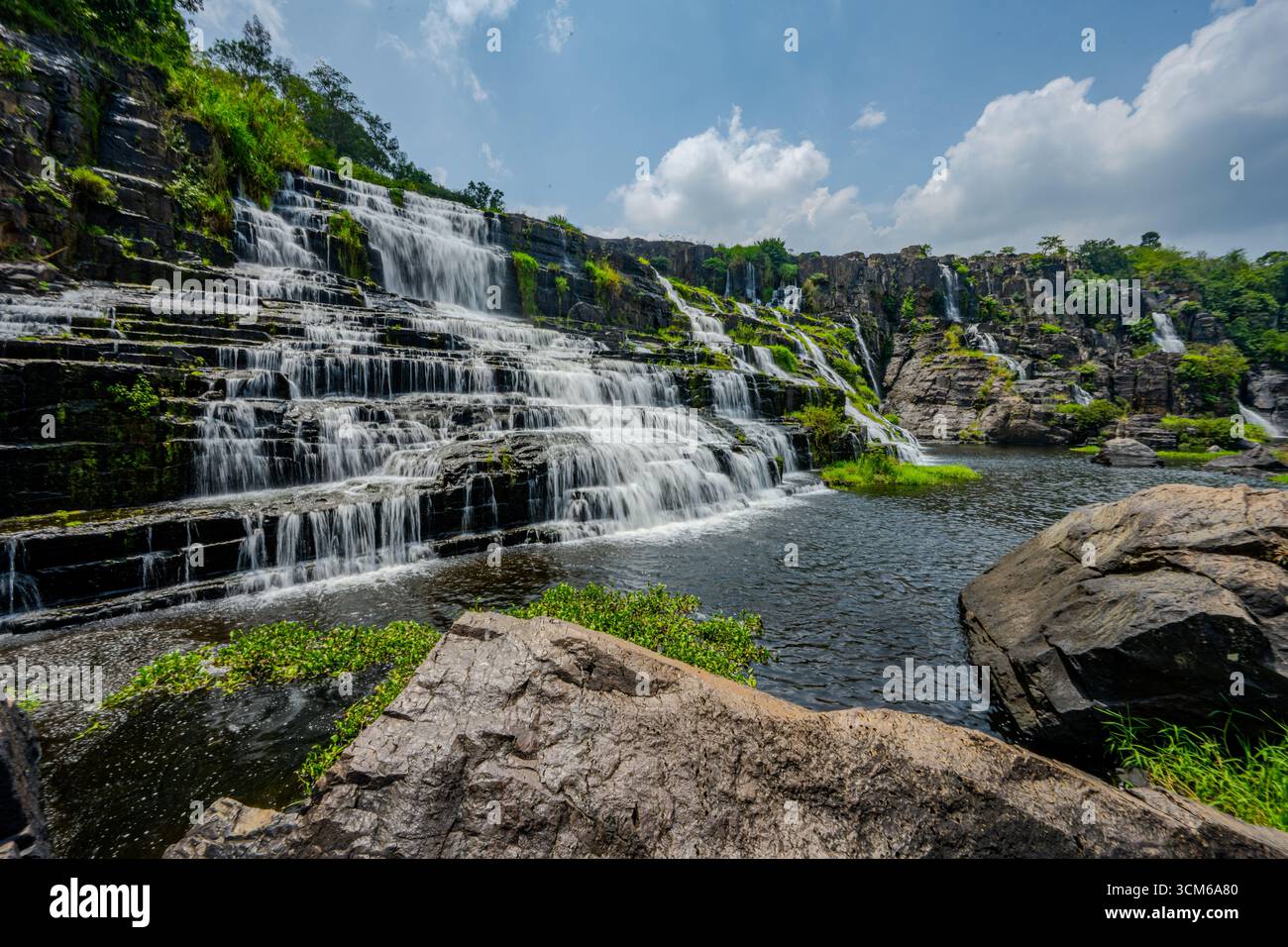 Ampia vista della cascata di Pongour che si getta sulle terrazze rocciose in una tranquilla piscina a da Lat, provincia di Lam Dong, Vietnam. Foto Stock