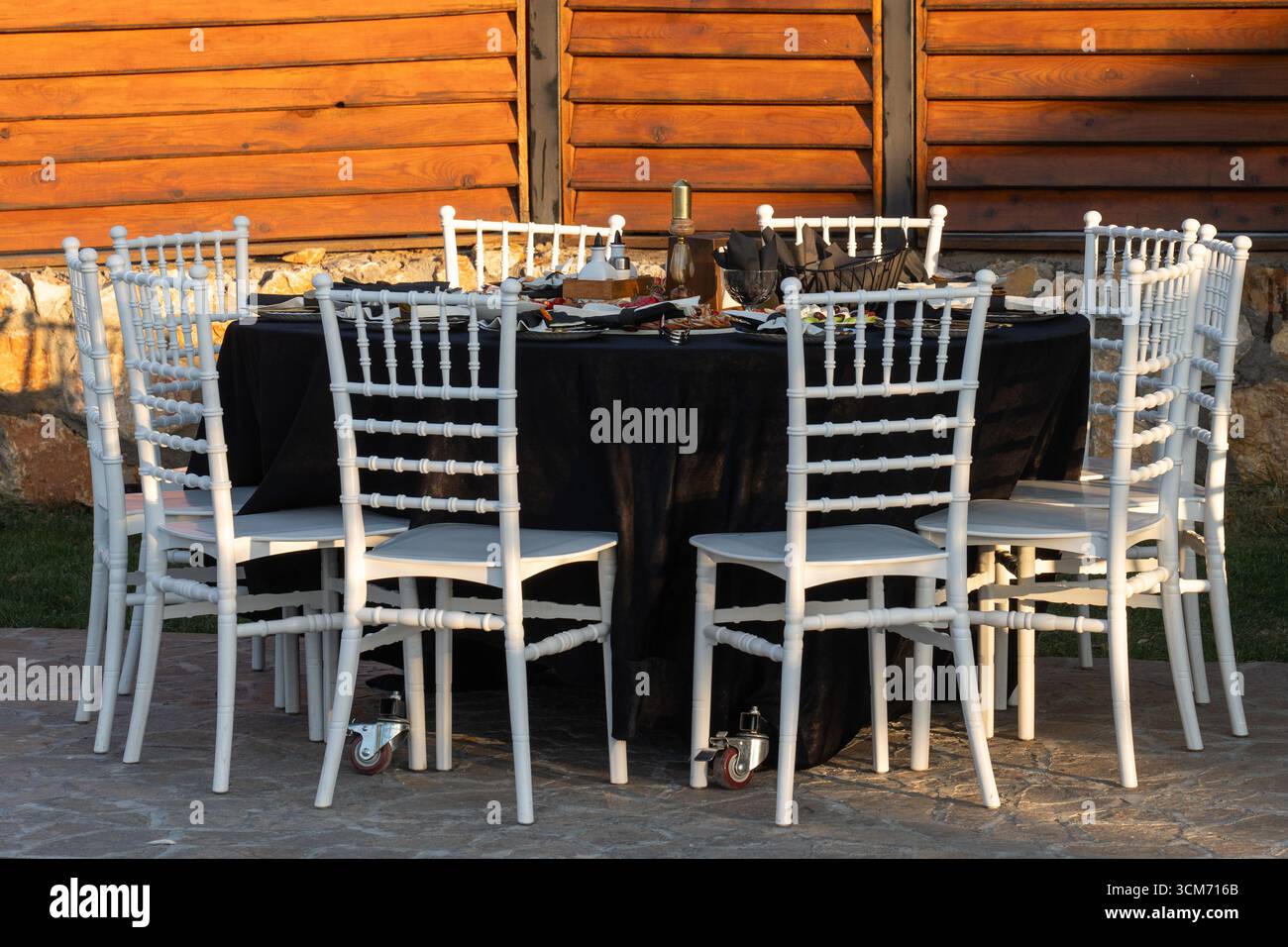 Banchetto rotondo con dieci sedie bianche - raduno al tramonto Foto Stock