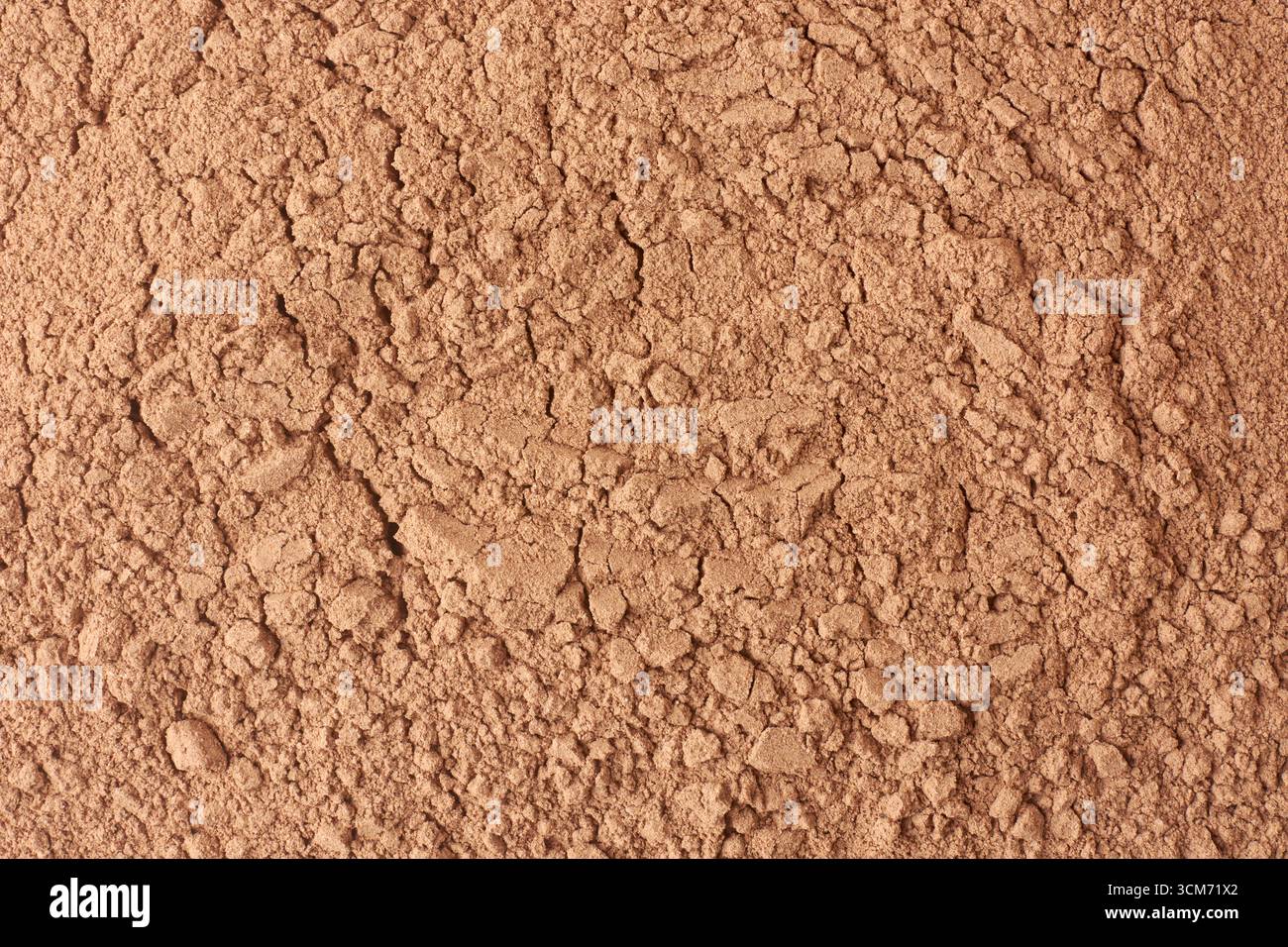 polvere di fosfato di roccia bruno-rossastro con superficie fessurata e consistenza granulare, nutriente essenziale per le piante, utilizzato come fertilizzante agricolo Foto Stock