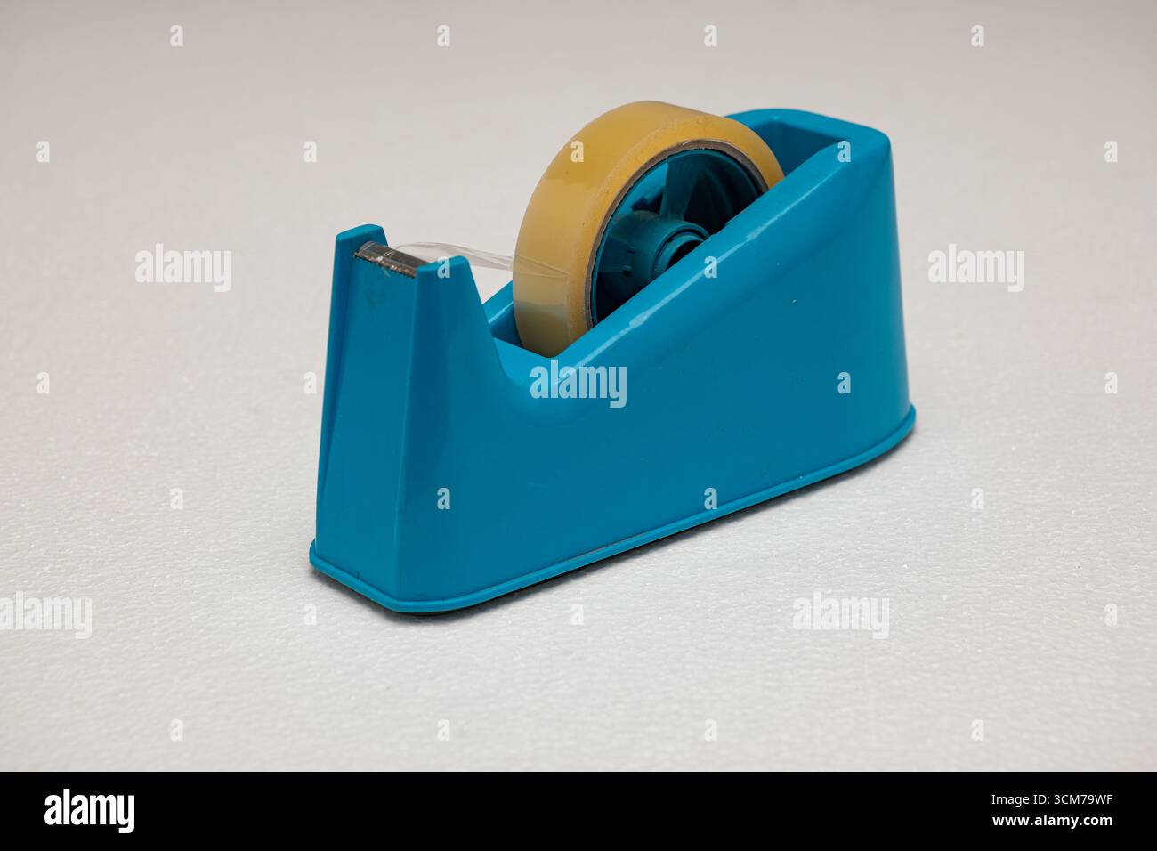Un dispenser di nastro blu con un rotolo di nastro trasparente Foto Stock