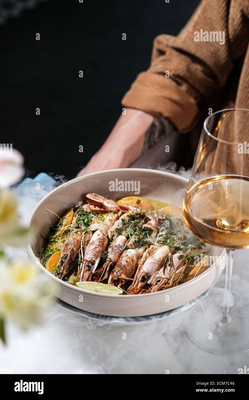 Assapora un piatto gourmet a base di pesce, preparato ad arte e abbinato perfettamente a un vino elegante Foto Stock