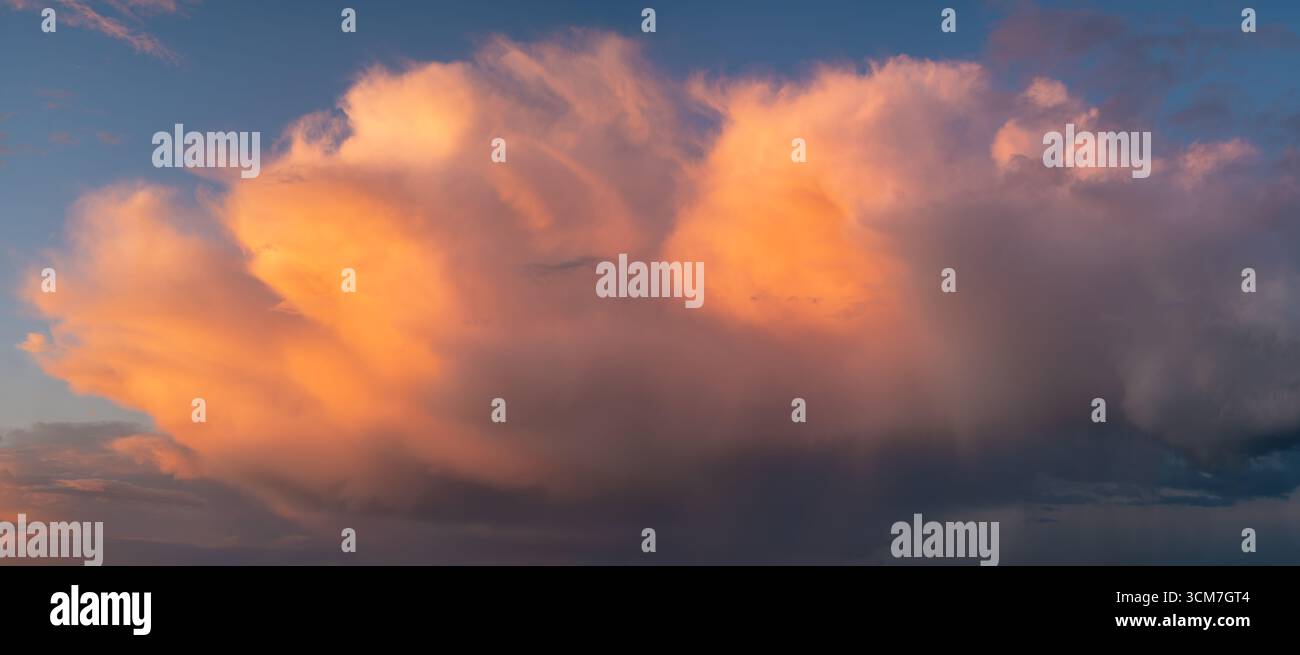 Nube di tempesta capillato cumulonimbus illuminata dal sole che tramonta Foto Stock