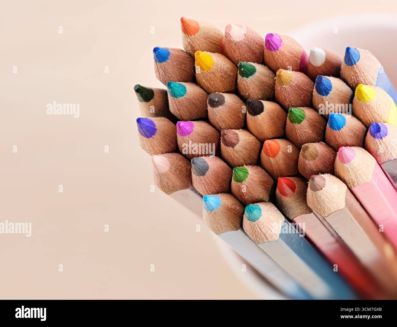 Matite colorate disposte a forma di triangolo, che mostrano tonalità vivaci e ispirano creatività nell'espressione artistica e nel design Foto Stock