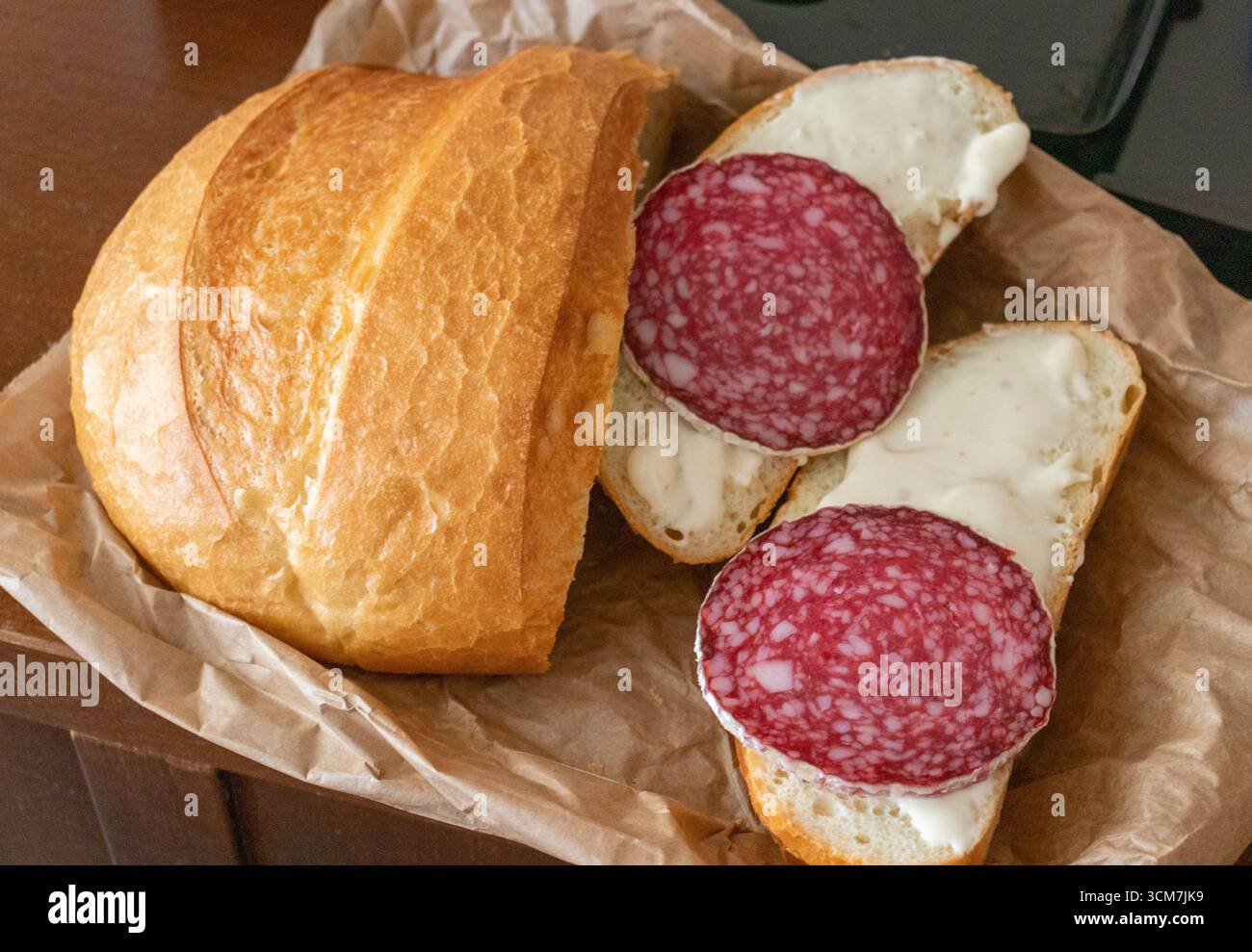 Pane fatto in casa sul sacchetto di carta, accanto ai panini Foto Stock