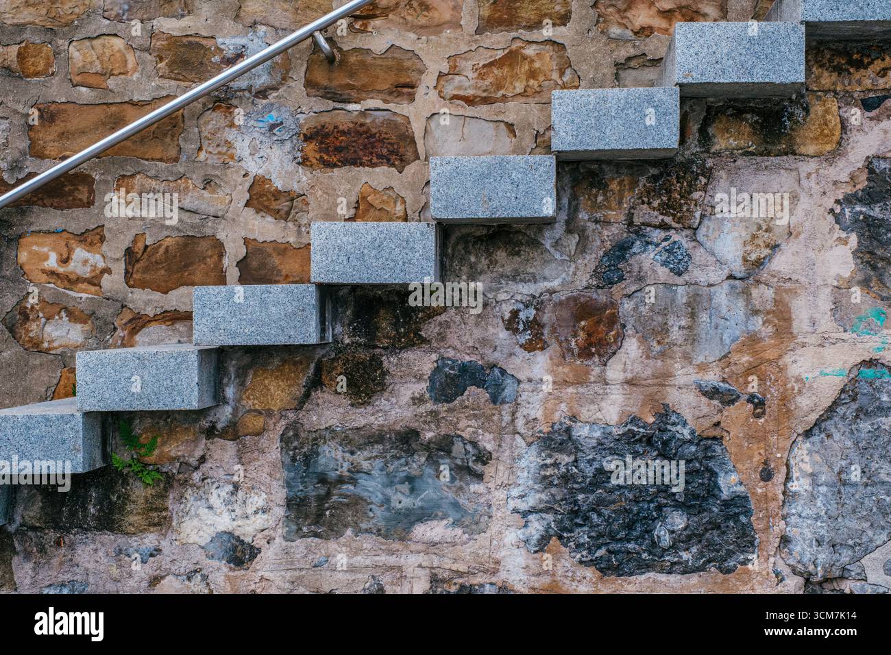 Gradini moderni in pietra grigia contro antiche mura che mostrano contrasto architettonico. Ristrutturazione contemporanea, conservazione storica Foto Stock