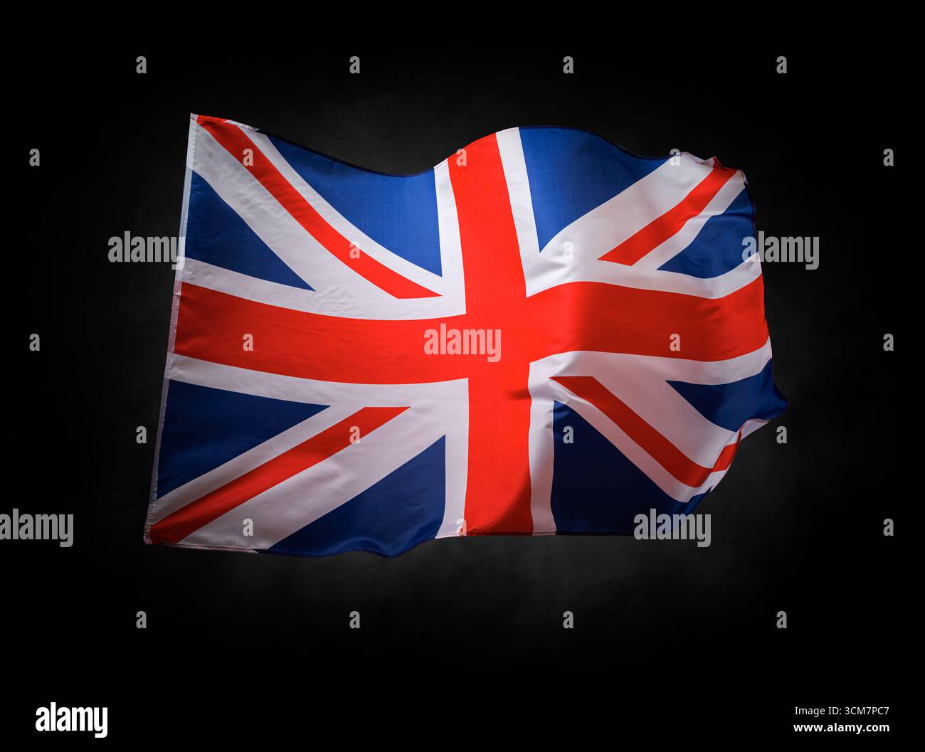 Bandiera del Regno Unito Union Jack che sventola su uno sfondo scuro Foto Stock