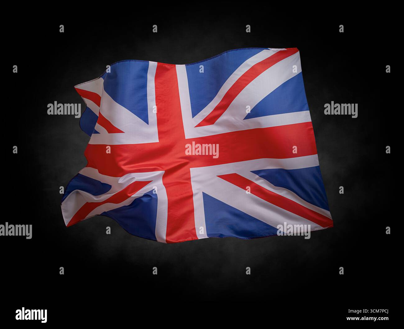 Bandiera del Regno Unito Union Jack che sventola su uno sfondo scuro Foto Stock