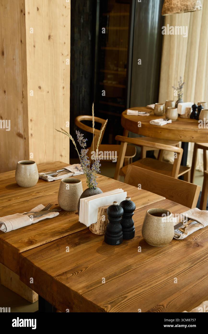 Cucina rustica con tazze in ceramica e tavoli in legno Foto Stock