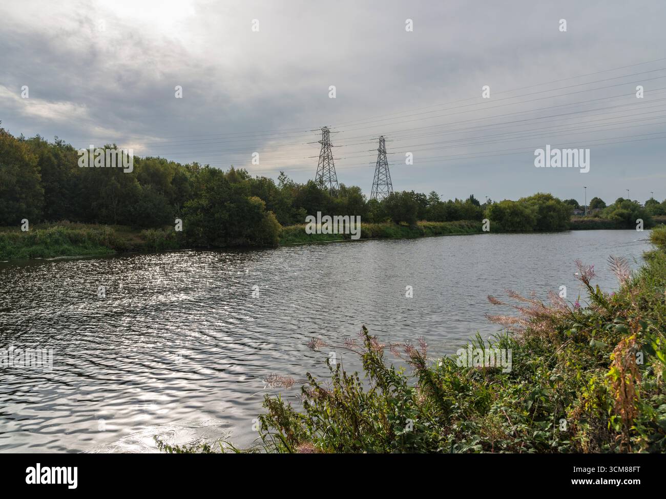 Linee elettriche che attraversano il fiume Mersey a Latchford, Warrington, Regno Unito. Presa in data 6 settembre 2025. Foto Stock