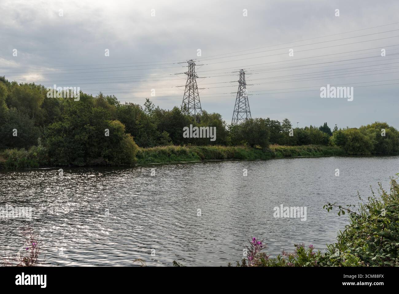 Linee elettriche che attraversano il fiume Mersey a Latchford, Warrington, Regno Unito. Presa in data 6 settembre 2025. Foto Stock