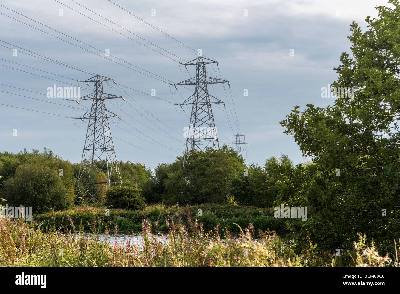 Linee elettriche che attraversano il fiume Mersey a Latchford, Warrington, Regno Unito. Presa in data 6 settembre 2025. Foto Stock