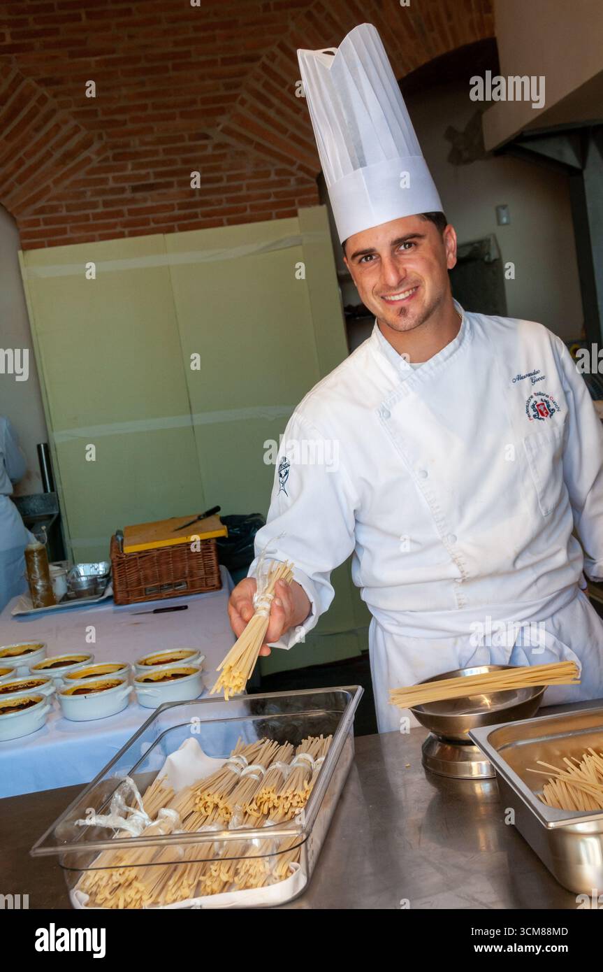 Uno chef sorridente espone un mucchio di pasta artigianale nella cucina di un ristorante a Rione Terra, Pozzuoli. Foto Stock