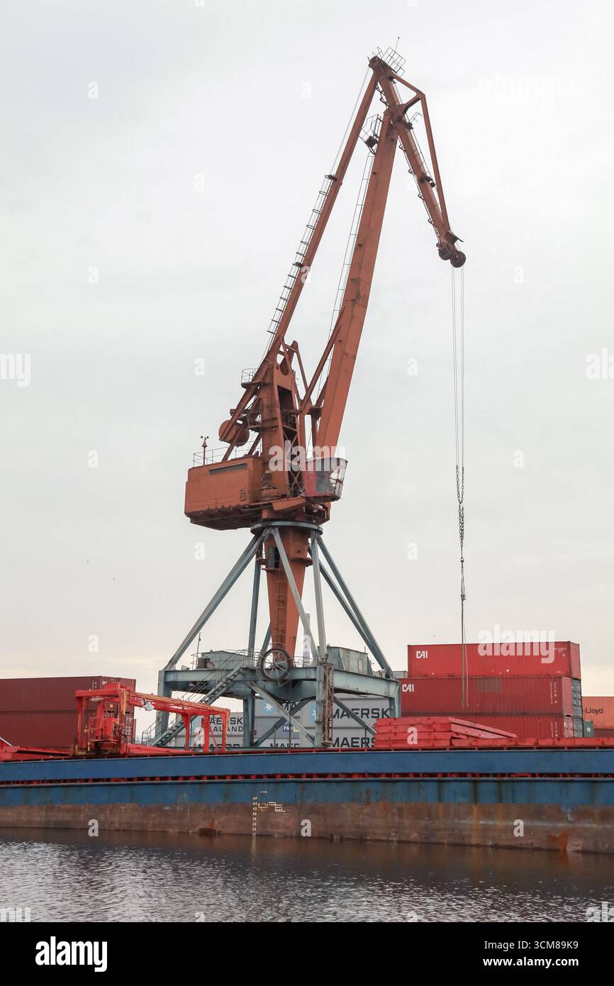 Varna, Bulgaria - 16 luglio 2014: Una grande gru industriale che solleva container merci in un porto, mostrando la logistica delle spedizioni. L'immagine cattura mariti Foto Stock