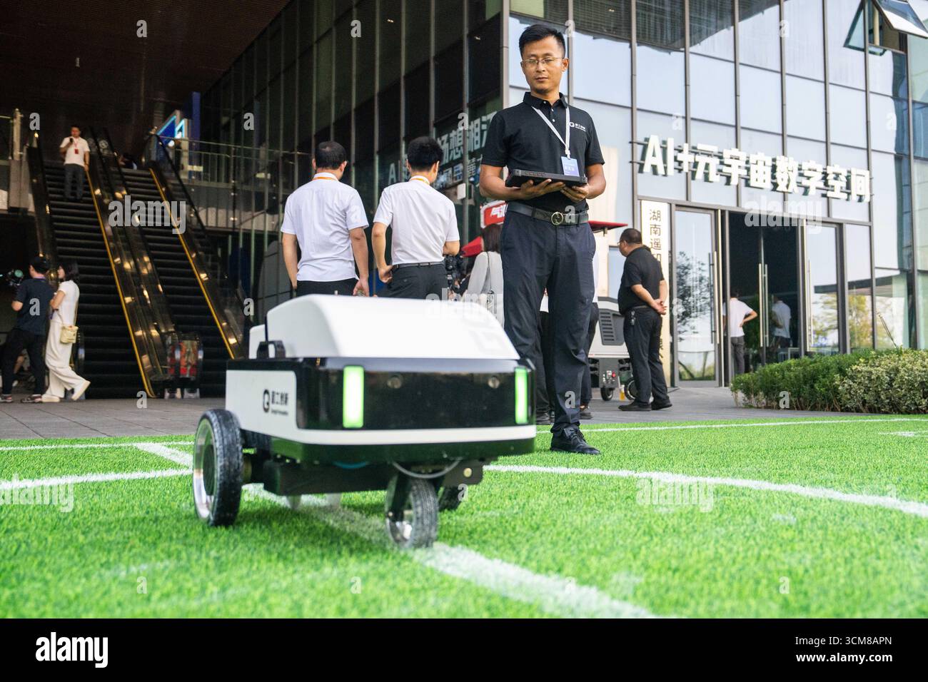 Changsha, la provincia cinese di Hunan. 15 settembre 2025. Un membro dello staff (front) gestisce un robot per disegnare linee progettato per i parchi giochi all'Internet Yuelu Summit 2025 nella nuova area di Xiangjiang a Changsha, nella provincia di Hunan della Cina centrale, 15 settembre 2025. Concentrandosi su tecnologie all'avanguardia come l'intelligenza artificiale, il summit è iniziato qui lunedì. Crediti: Chen Sihan/Xinhua/Alamy Live News Foto Stock