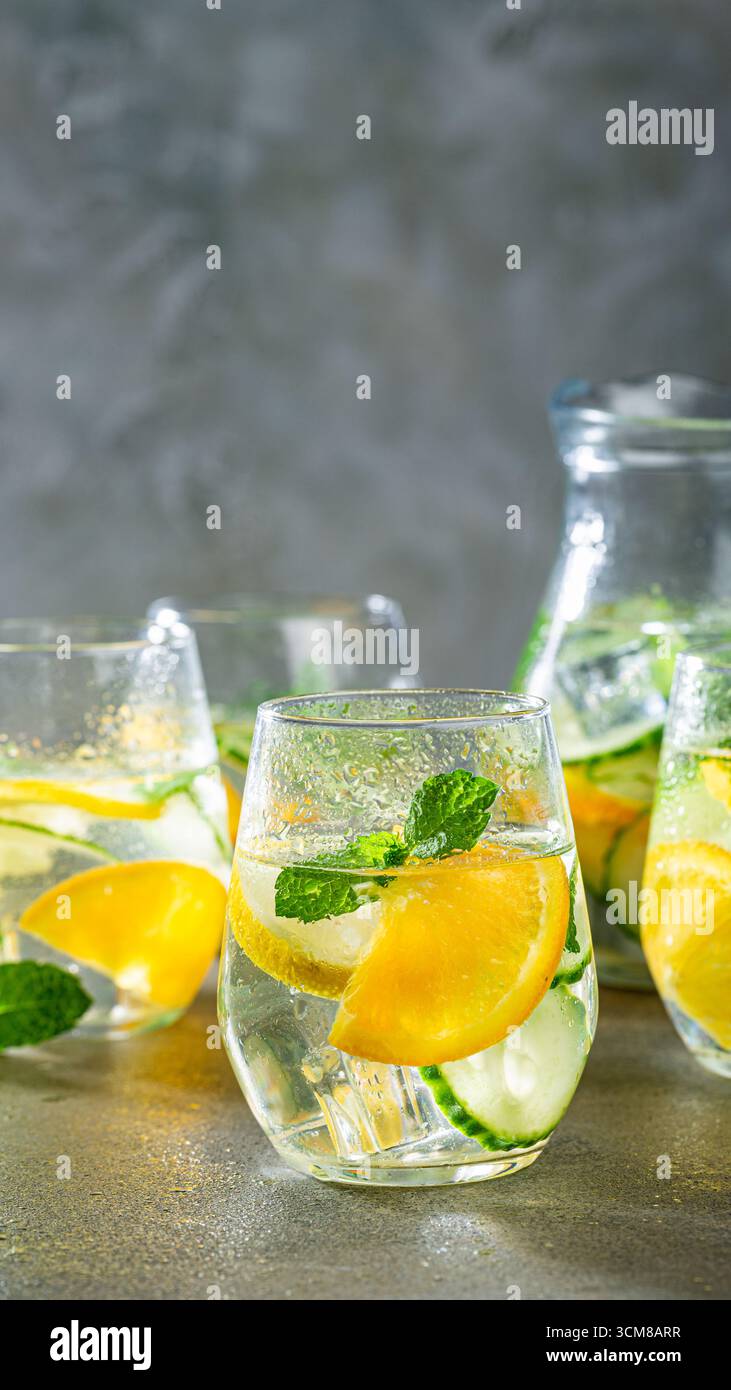 Limonata servita in bicchieri con foglie di menta e fette di limone, accanto a una caraffa, creando un'atmosfera rinfrescante da drink estivo, sfondo telefonico con copia Foto Stock