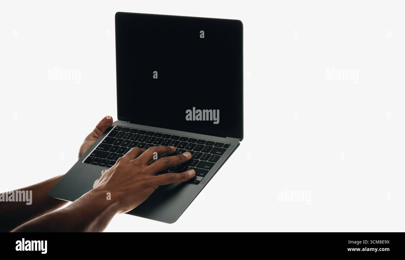 Vista ravvicinata delle mani che gestiscono un notebook con schermo nero vuoto, isolato su uno sfondo bianco minimalista. L'immagine richiama un senso di Foto Stock