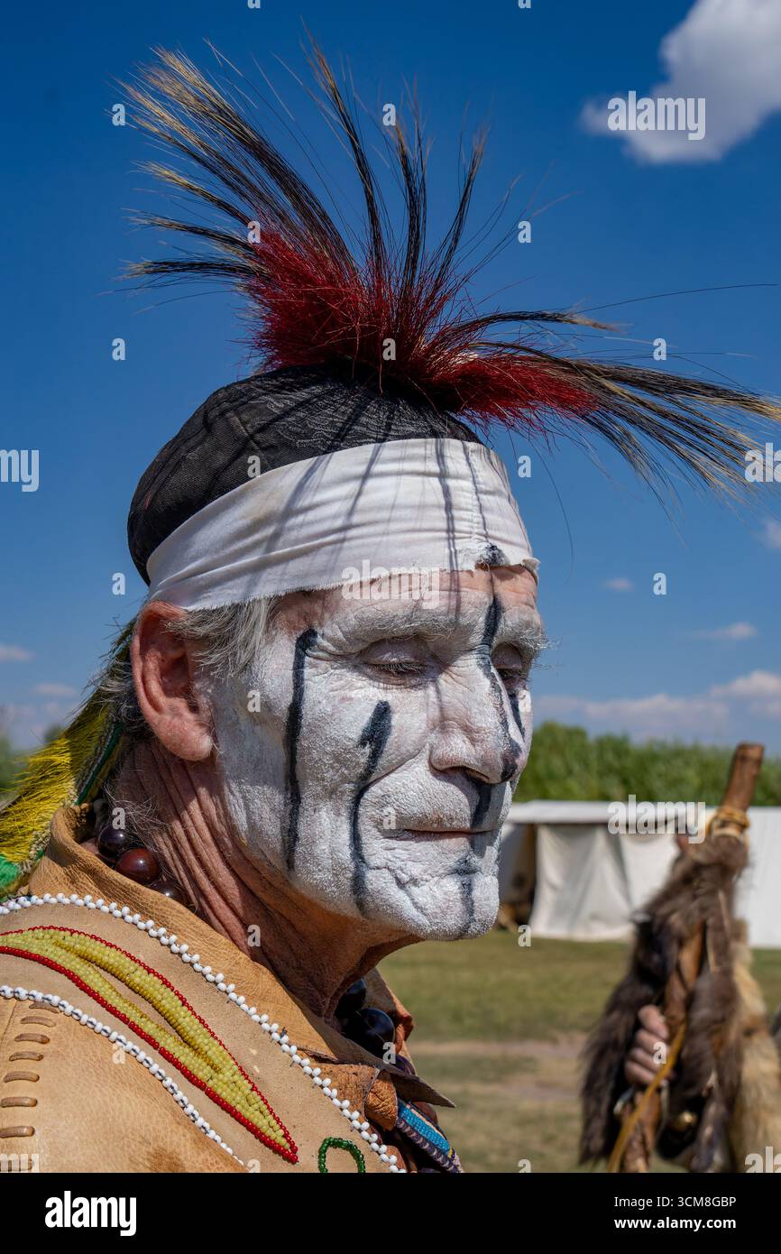 Un amerindo con il viso dipinto in abito d'epoca al Fort Bridger Mountain Man Rendezvous in Wyoming. Foto Stock