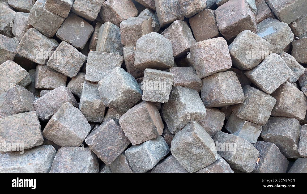 Blocchi di granito di pavimentazione impilati in ammassi di pietre Foto Stock