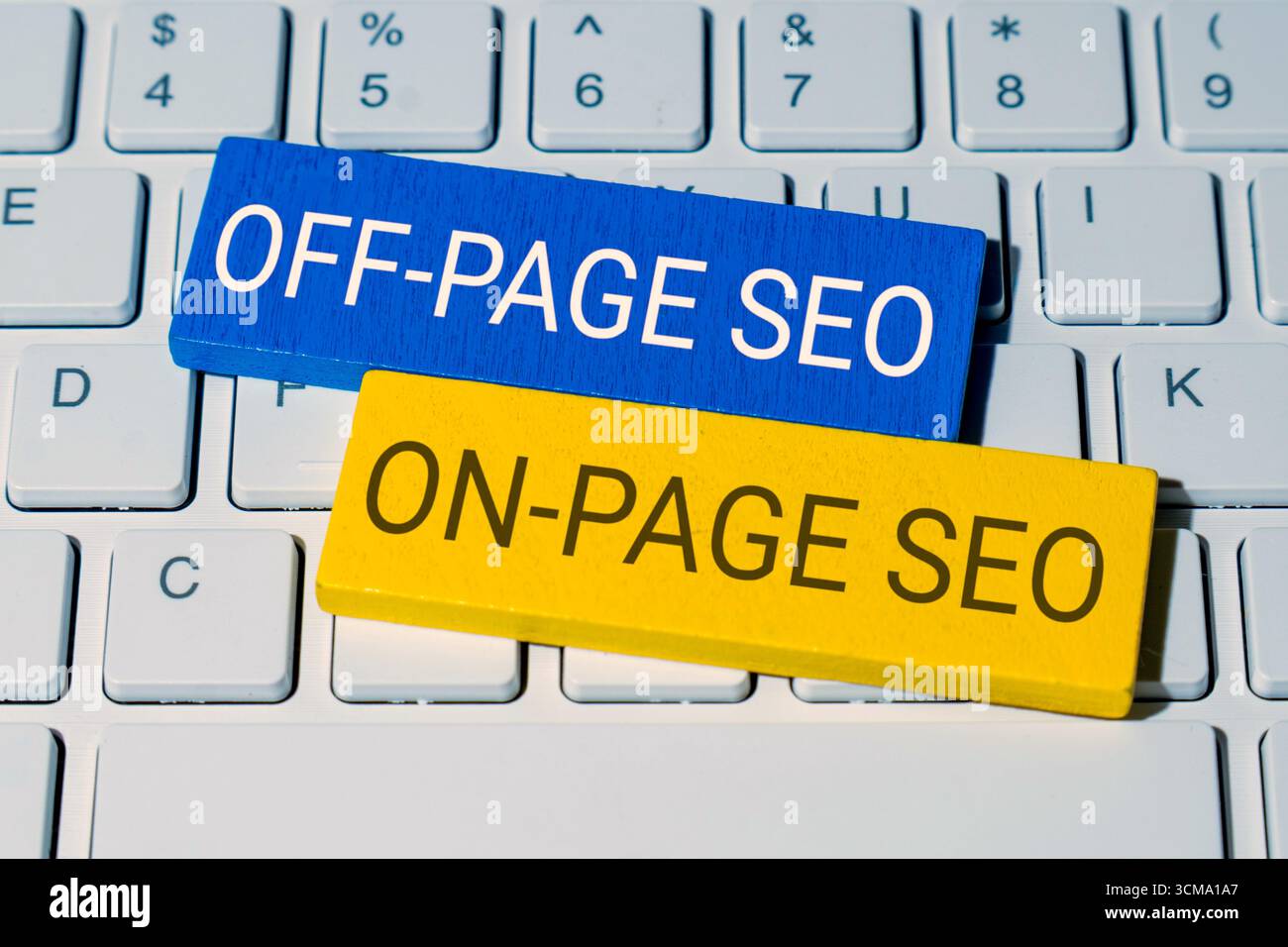 Blocchi di legno sulla tastiera di un notebook con testo SEO fuori PAGINA e SEO ON-PAGE. Ottimizzazione dei motori di ricerca e concetto di strategia di marketing digitale. Foto Stock