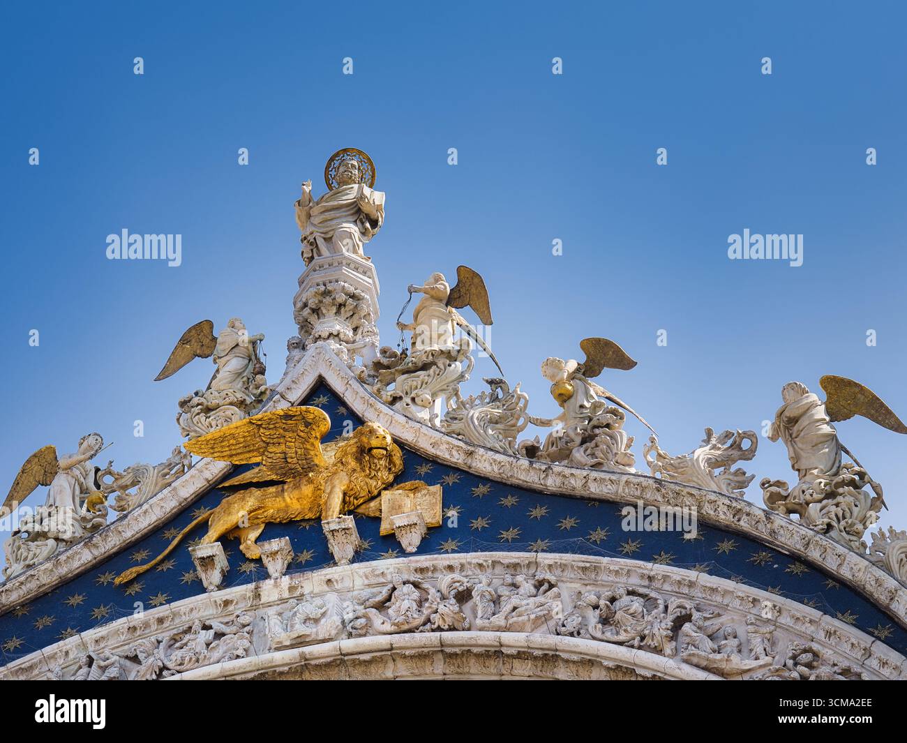 Leone alato di San Marco e statue sulla grondaia della Basilica di San Marco a Venezia, Italia, sotto un cielo blu limpido. Foto Stock