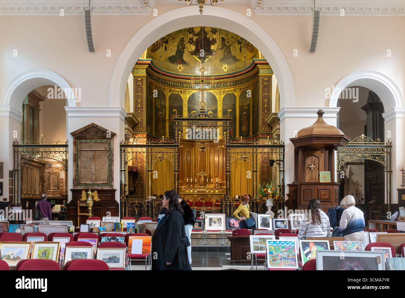 Persone che guardano alla mostra d'arte nella Holy Trinity Church nel centro di Guildford, Surrey, Inghilterra, Regno Unito Foto Stock